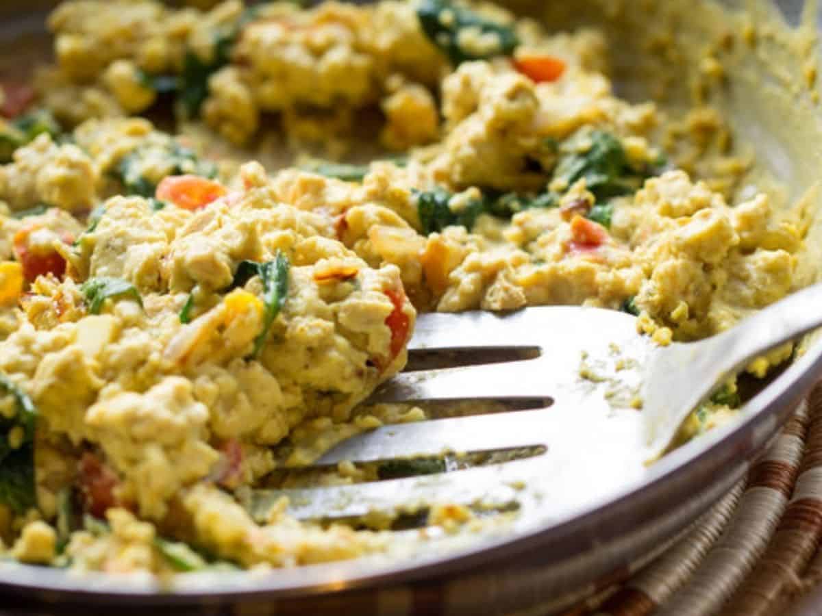 tofu scrambled in a skillet with a spatula