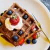 a stack of brownie waffles with fruit