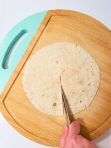a tortilla being cut with a knife