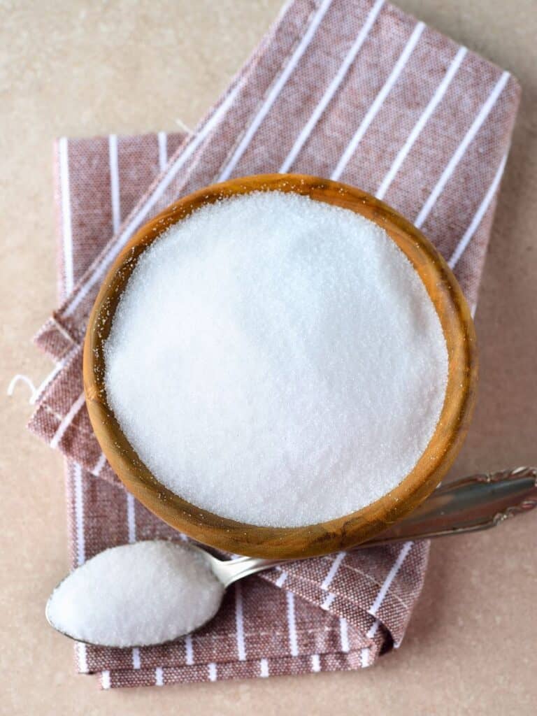 a bowl and spoon of allulose on top of a napkin