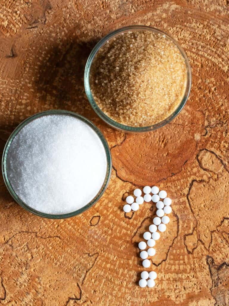 a bowl of allulose ad a bowl of monk fruit with sugar substitute tablets in a question mark