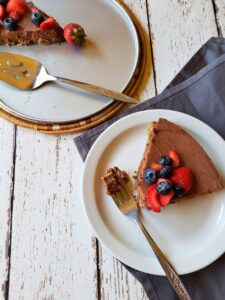 a slice of no bake coffee cheesecake next to a springform pan with cheesecake