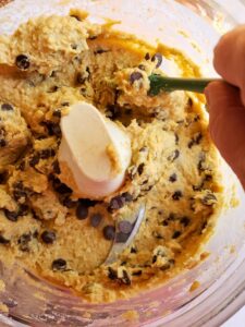 chocolate chips being folded into edible cookie dough in a food processor