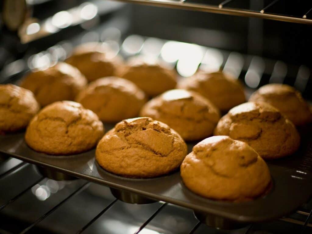 pumpkin muffins in a tin in an oven