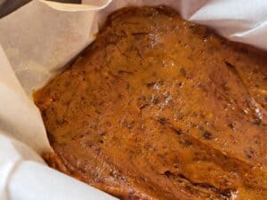 pumpkin fudge pressed into a lined pan