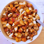 butternut squash casserole in a white serving bowl