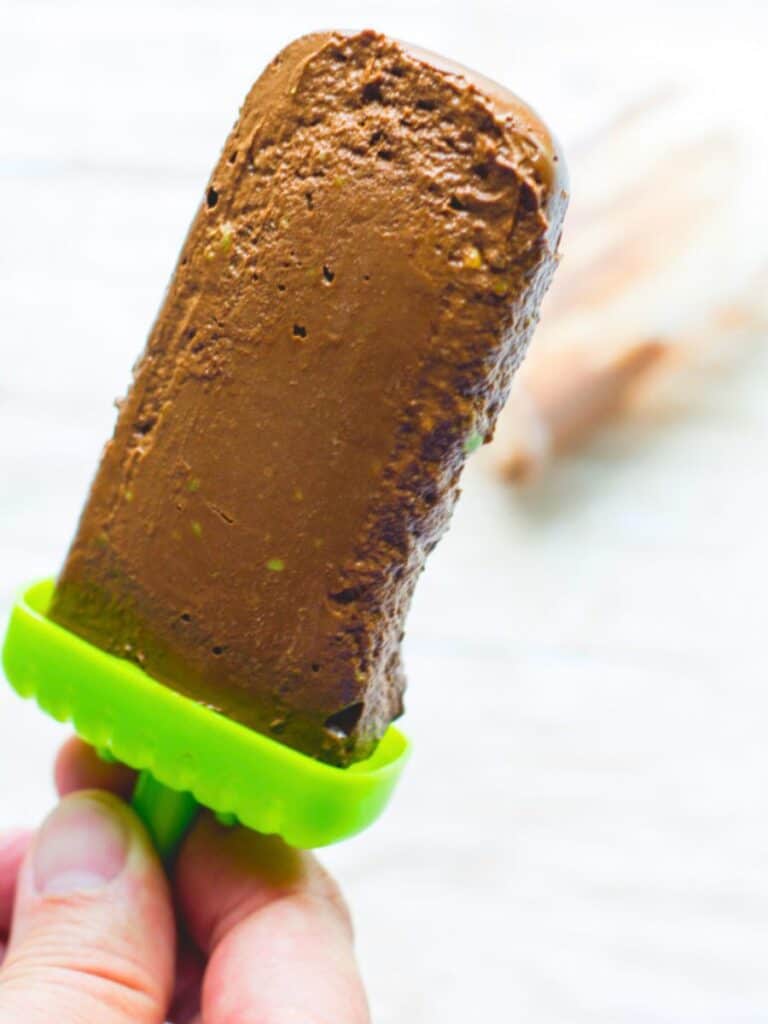 avocado fudgesicle being held by a hand