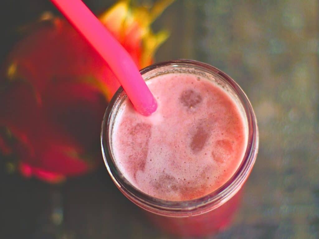 dragon fruit refresher in a glass with a pink straw