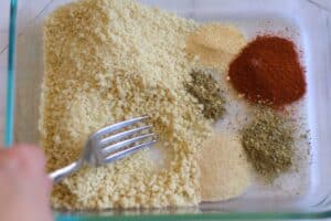 bread crumbs being mixed with spices