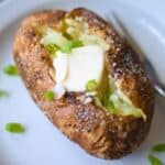 Baked potato with vegan butter and green onions