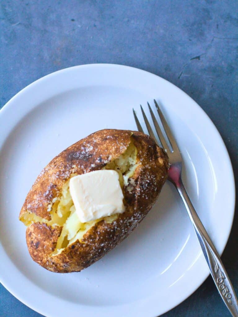baked potato on a plate with a fork