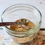 spice mix in a small glass jar with a tablespoon