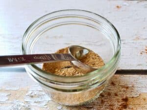 spice mix in a small glass jar with a tablespoon