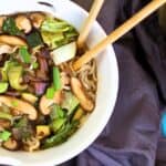 a bowl of black bean ramen with chopsticks
