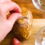 salt being sprinkled over a potato