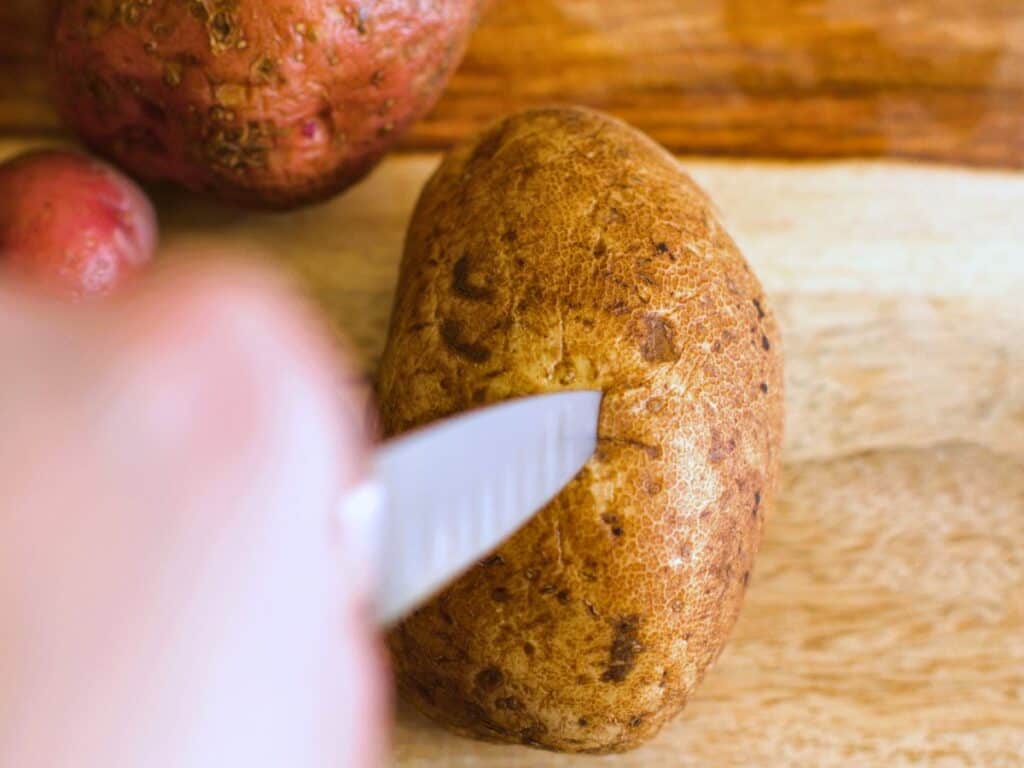 a knife being inserted into a potato