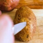 a knife being inserted into a potato