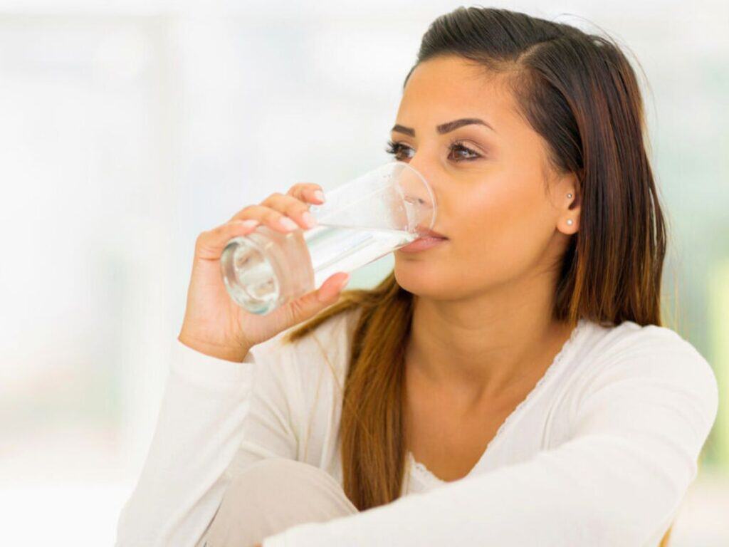 a woman drinking a glass of water