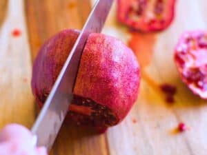a knife cutting a pomegranate