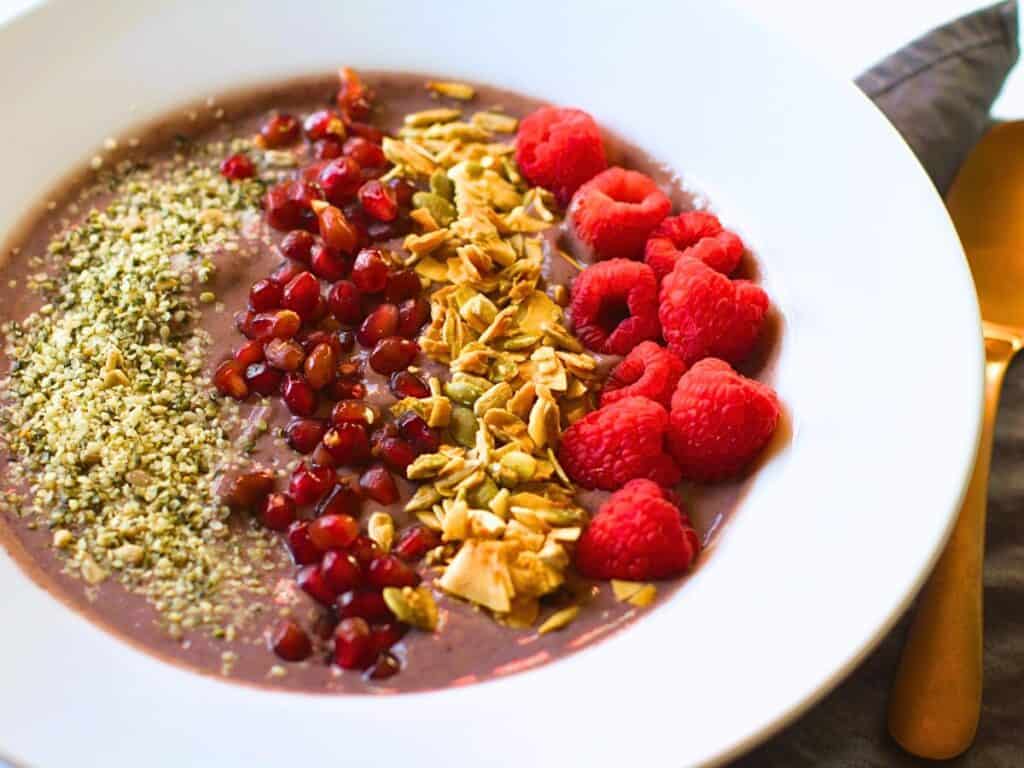smoothie bowl without a banana but has raspberries and pomegranate arils