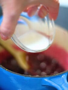 cornstarch slurry being added to blueberries