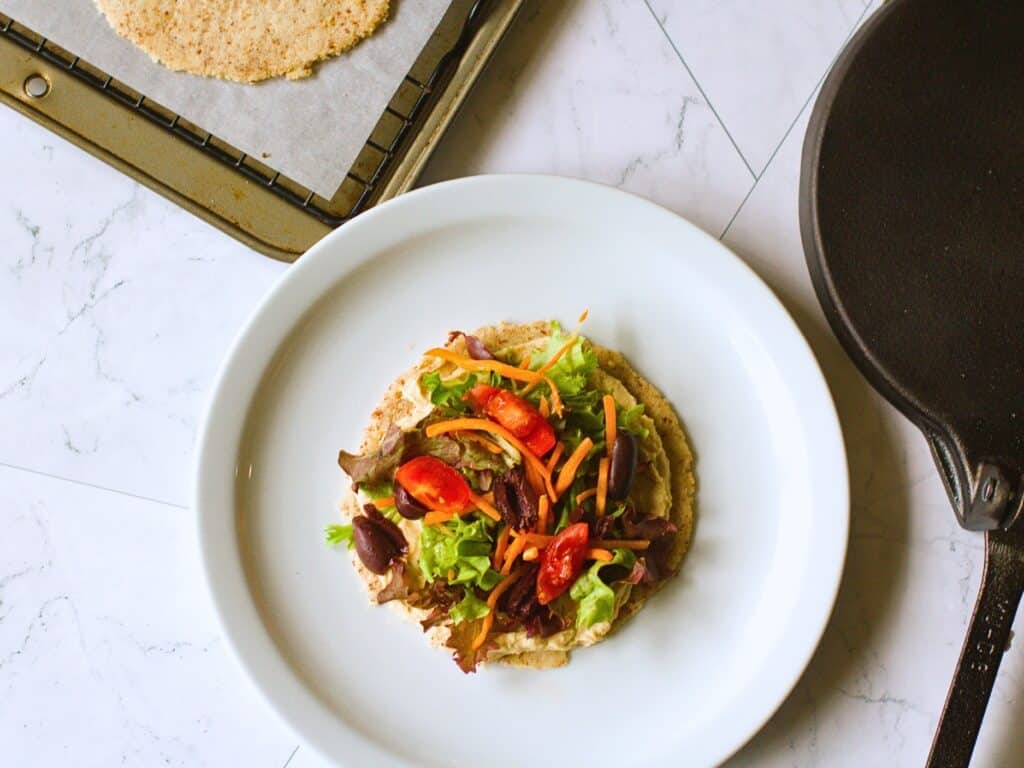 almond flour tortilla next to a tortilla press