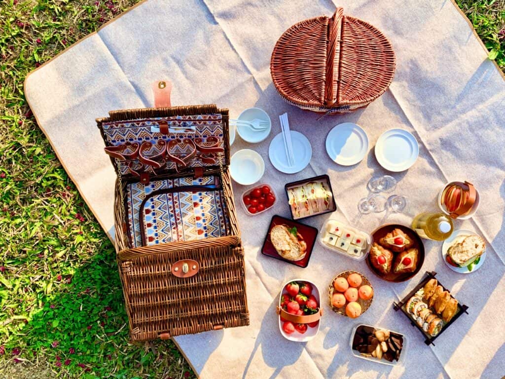 picnic basket surrounded by food and plates