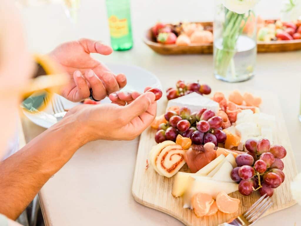 people surrounding a charcuterie board outside