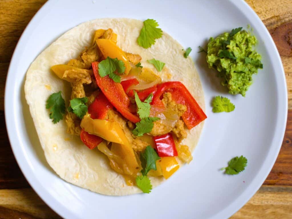 veggie fajitas on a flour tortilla with guacamole