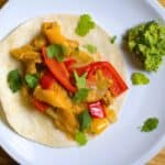veggie fajitas on a flour tortilla with guacamole