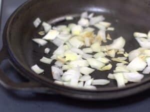 onions sauteing in a cast iron skillet