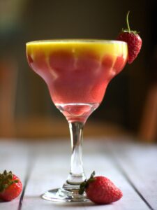 smoothie in a glass surrounded by strawberries