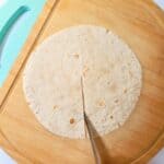 a flour tortilla being sliced