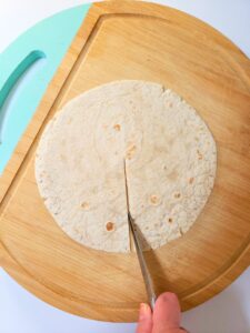 a flour tortilla being sliced