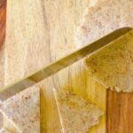 a hand with a knife cutting a keto tortilla into chips