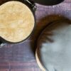 a tortilla on a tortilla press next to a tortilla warmer