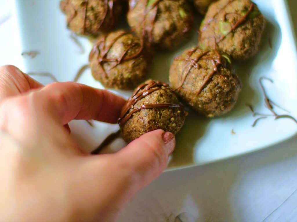 a hand reaching for a protein ball