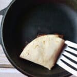 a tortilla being heated in a skillet