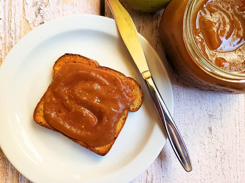 apple butter on toast with a jar of apple butter next to it