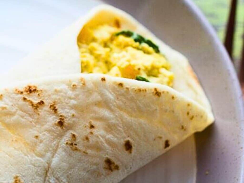 a breakfast burrito filled with tofu scramble