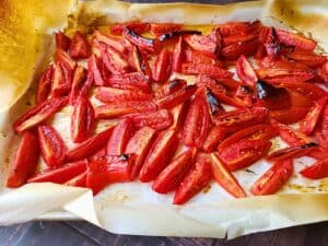 roasted tomatoes and peppers on a baking sheet