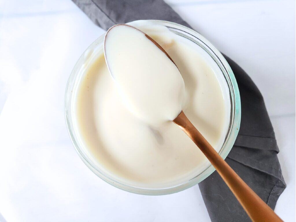 a spoonful of yogurt resting across a glass dish