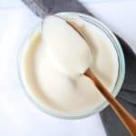 a spoonful of yogurt resting across a glass dish