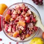 a bowl of fall fruit salad with a wooden spoon