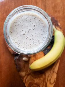 a vanilla protein shake surrounded by a banana and beans