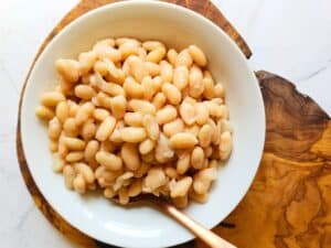 a bowl of white beans with a spoon