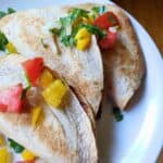spicy potato tacos on a plate with pico de gallo